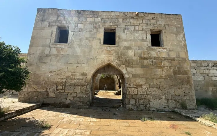 Tarixi karvansaranın üzərindəki yazıları qum-sementlə örtüblər - Fotolar